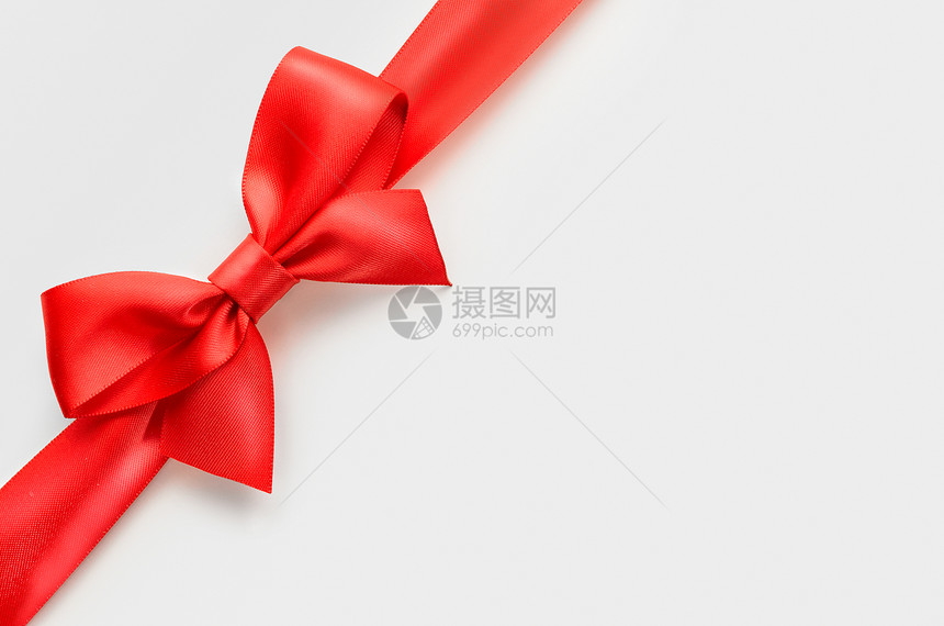 白色背景上的红色缎子蝴蝶结,整个物体用裁剪路径切割图片