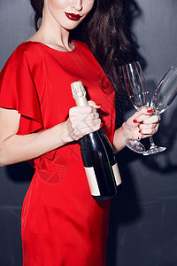 穿着红色连衣裙的黑发女人,带着瓶香槟两个璃杯穿红裙子的女人喝香槟图片
