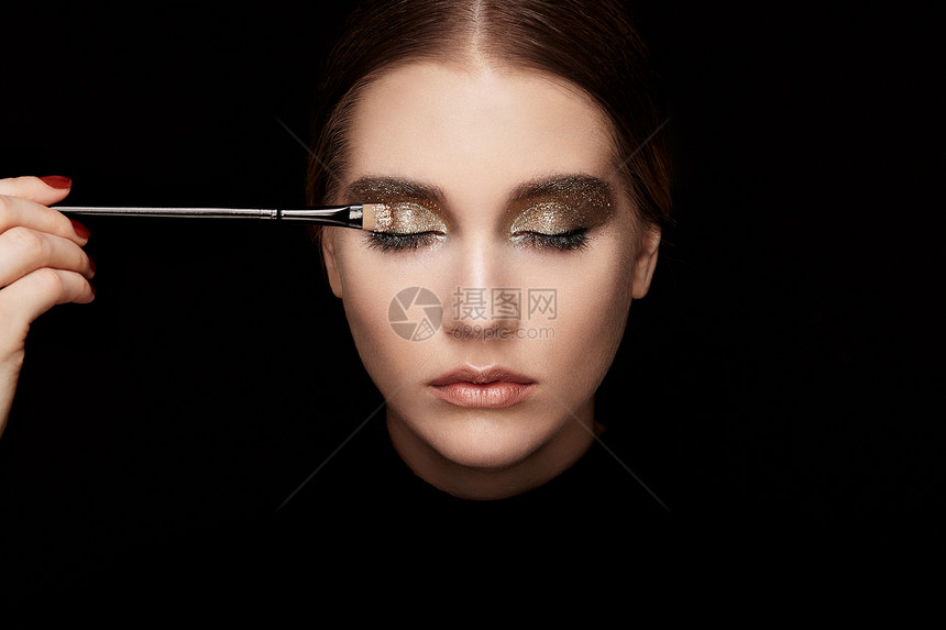 化妆师应用眼影漂亮的女人脸完美的妆容嘴唇化妆品眼影化妆细节眼线图片
