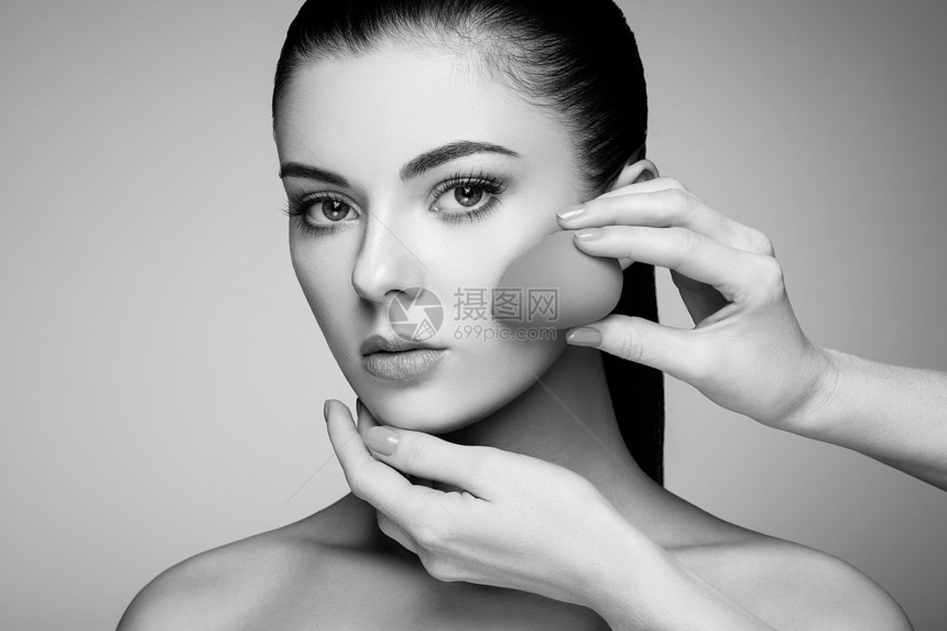 化妆师应用斯金通漂亮的女人脸完美的妆容护肤基金会海绵化妆师图片