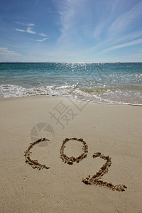 海滩上的氧化碳热带海滩的沙滩上手写的氧化碳背景图片