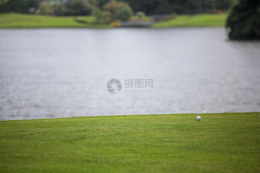 球场上的高尔夫球高尔夫球球场上,池塘背景上图片