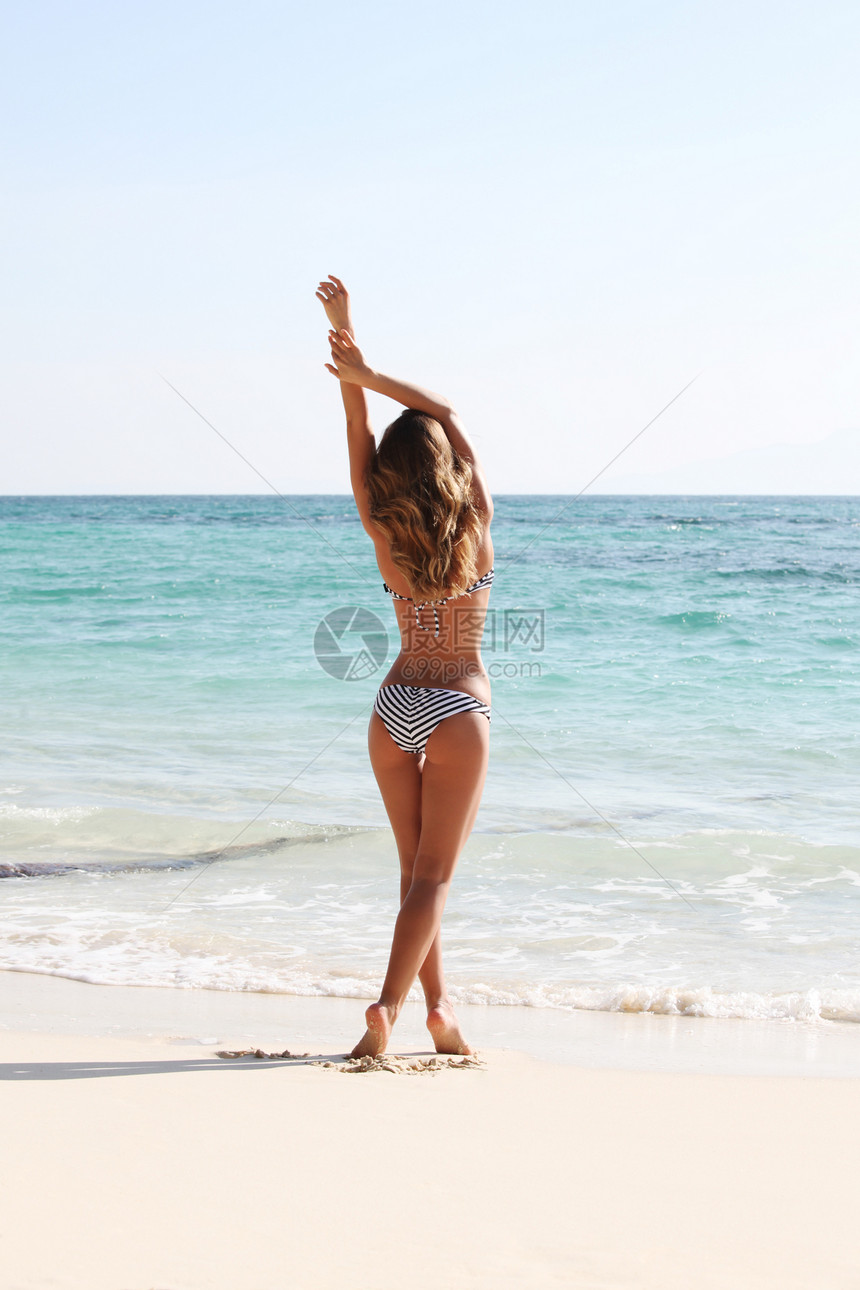美丽的女人海滩上看着大海,后视镜图片