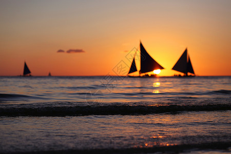 日落时的游艇日落时热带海洋航行的游艇图片