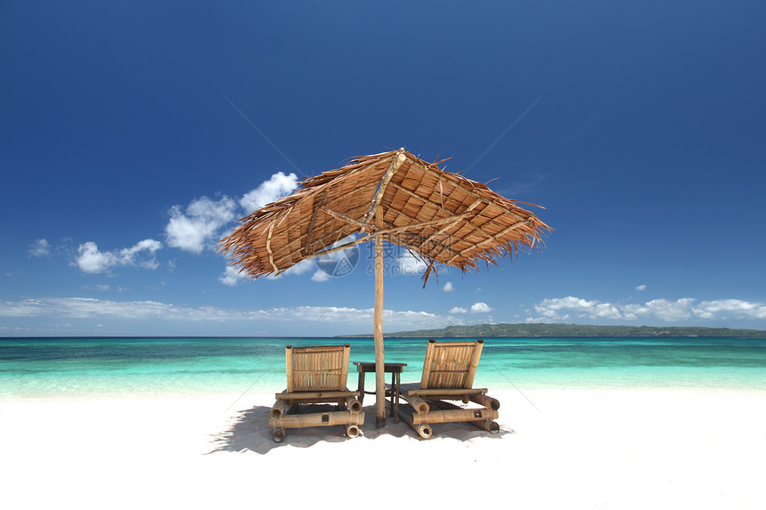 海滩上阳伞的椅子菲律宾白色沙滩上,用稻草阳伞放松沙发椅图片