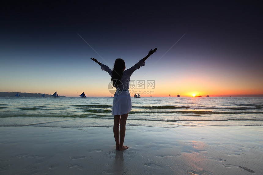 女人海边日落海边日落时举手的女人图片