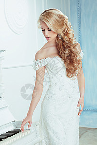 新娘着别致的发型,钢琴旁边摆姿势高清图片