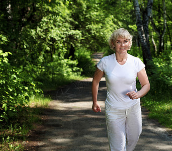 老妇人喜欢公园里跑步健康的生活方式背景图片