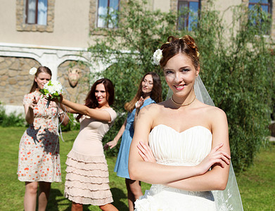 穿着白色婚纱的轻新娘向伴娘扔了花高清图片