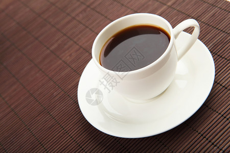 黑色咖啡白色杯子茶托白色黑暗的背景图片