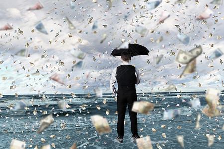 轻的商人金钱雨下着雨伞站着图片