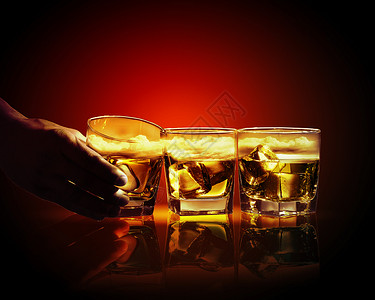 三杯威士忌加冰块手着三杯威士忌中的杯,冰天空插图图片