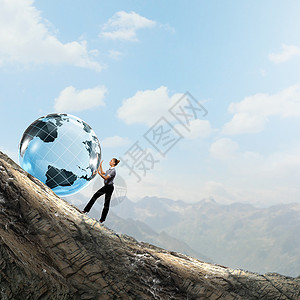 全球技术轻的女商人把地球滚山上图片