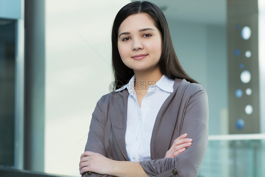 办公楼里魅力的女人轻的黑发女人现代璃内部手臂交叉胸部图片