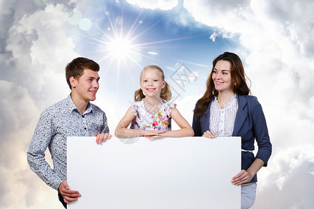 轻的家庭幸福的家三口着白色的空白横幅文字的位置图片