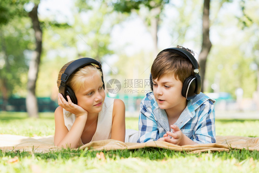 夏天公园野餐夏天公园里可爱的男孩女孩听音乐图片