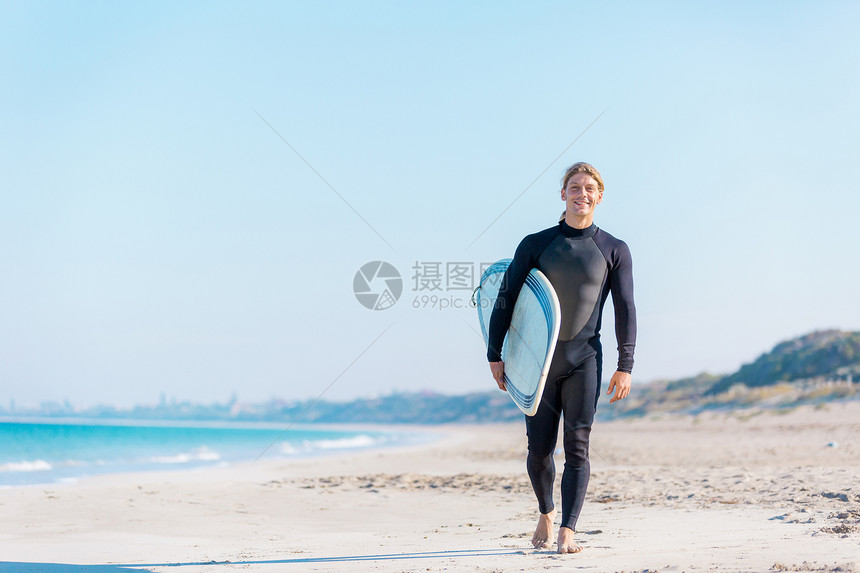 个轻的冲浪者海滩上冲浪准备好打浪了图片