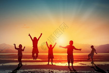 快乐粗心的童群孩子夕阳的背景下欢快地跳高的剪影背景图片