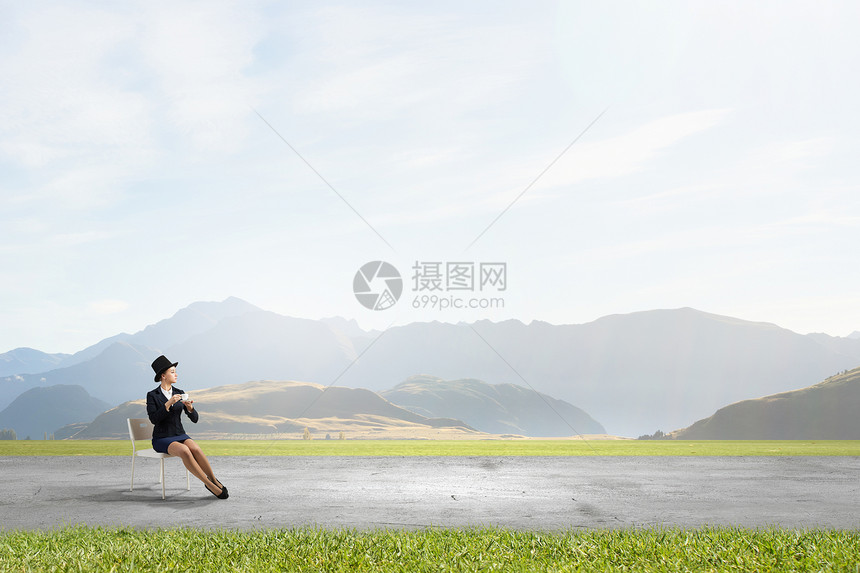 喝杯咖啡休息下漂亮的女孩戴着复古帽子坐椅子上,手里着杯子图片