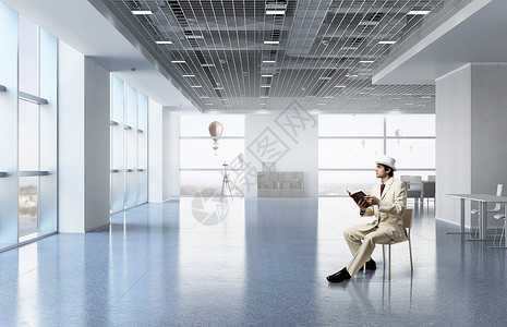 商人读书穿着白色西装的优雅商人坐办公室椅子上图片