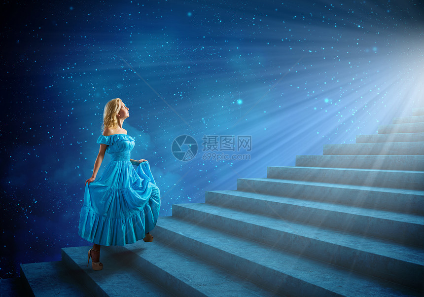 穿蓝色裙子的女孩穿着蓝色连衣裙的轻金发女人走上楼梯图片