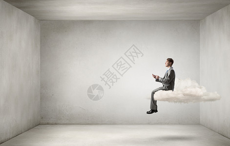 男人用他的手机轻的商人坐云端,手里着手机图片