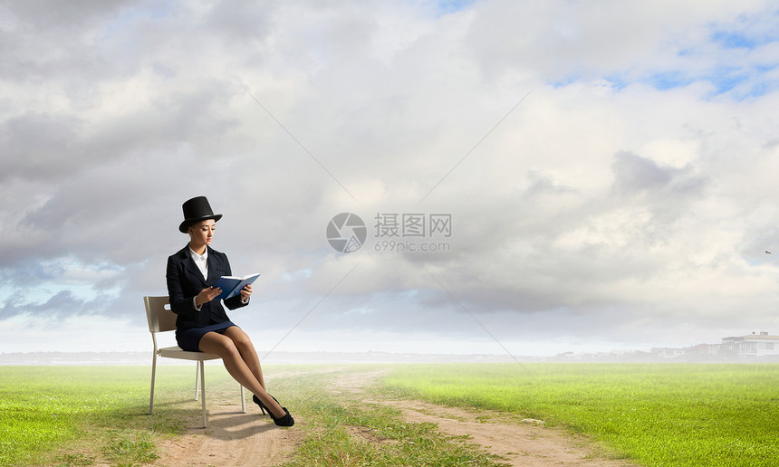 穿着黑色圆筒的女孩漂亮的女孩戴着复古帽子坐椅子上,手里着书图片