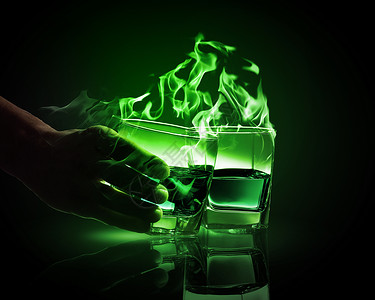 两杯绿色的苦艾酒手着两杯燃烧的绿色苦艾酒中的杯图片