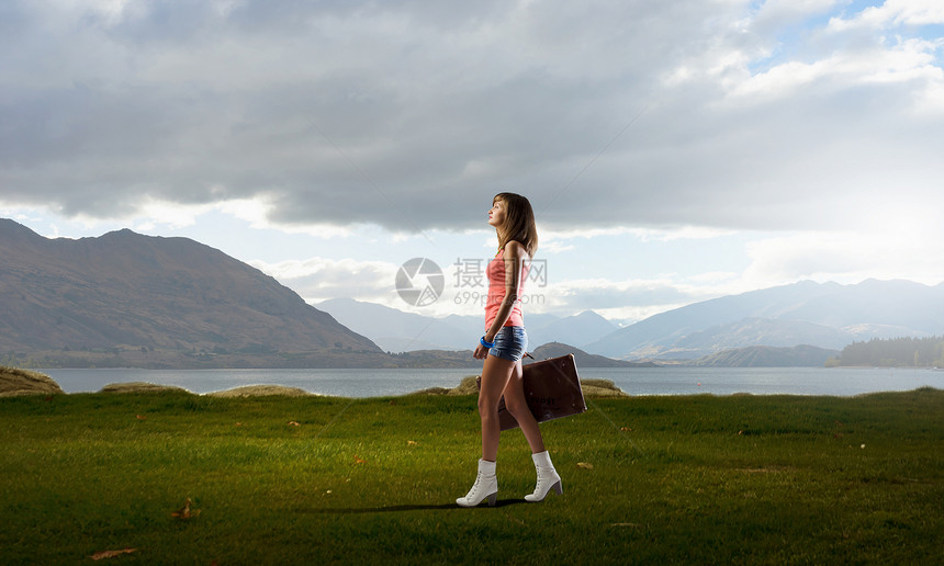 轻的搭便车旅行者轻漂亮的女孩手里着复古的手提箱走着图片