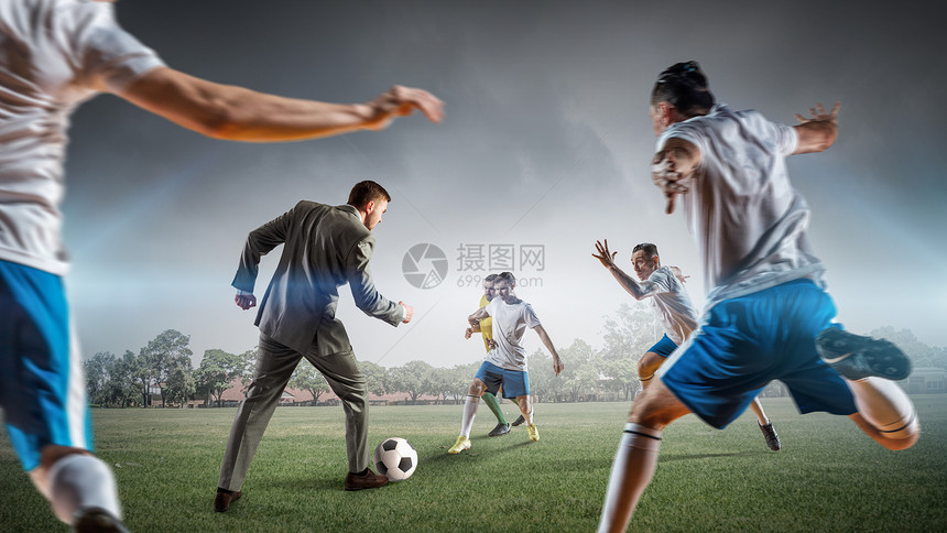 商人打球穿西装的轻商人户外球员踢足球图片