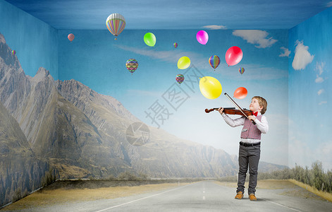 拉小提琴男孩他很少天赋可爱的男孩穿着红色的蝴蝶结,拉小提琴背景