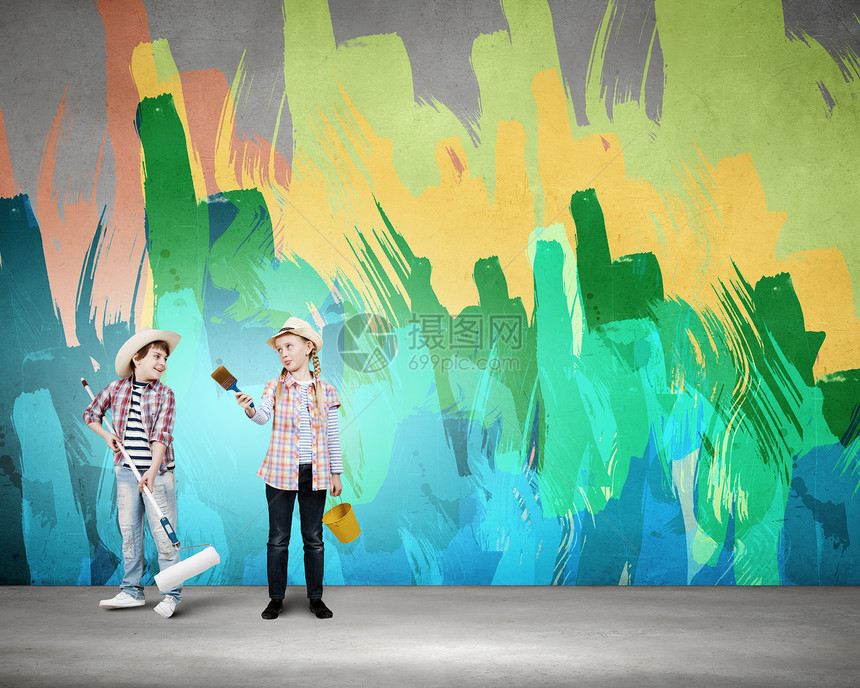 丰富多彩的童两个学龄儿童用滚筒画墙图片