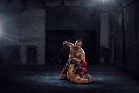 两个拳击手的战斗强大的拳击手黑暗的工业内部中战斗图片