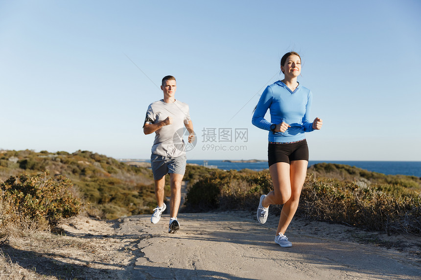 运动跑步者海滩上慢跑,她的搭档锻炼适合女健身模式慢跑沿海洋与她的伴侣图片