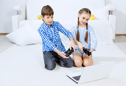 孩子们玩游戏控制台可爱的孩子坐地板上玩游戏杆图片