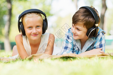 夏天公园野餐夏天公园里可爱的男孩女孩听音乐图片