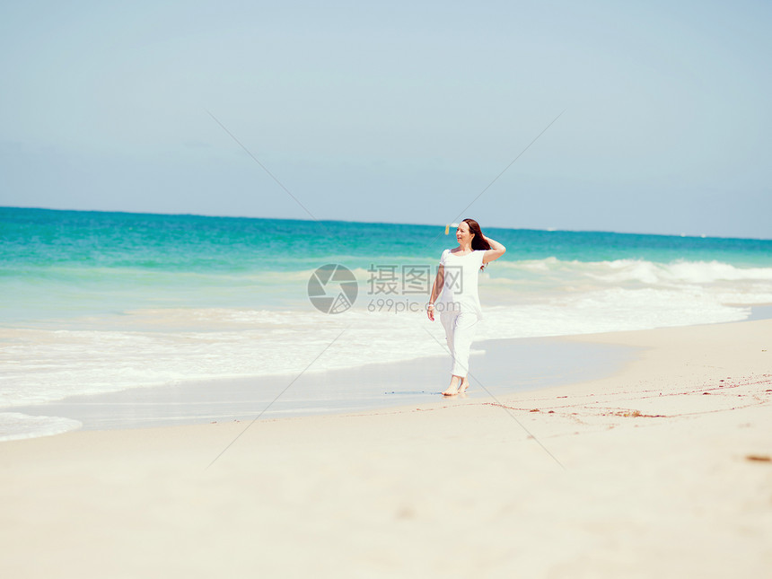 阳光明媚的天,海滩上穿着白色衣服的女人海滩上美好的天图片