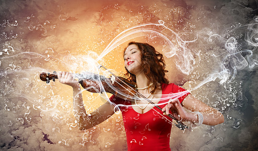 女小提琴手穿着红色连衣裙的轻漂亮女人拉小提琴图片