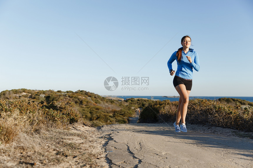 运动跑步者海滩上慢跑锻炼适合女健身模型沿海洋慢跑图片