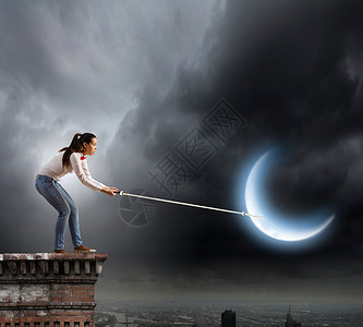 女人抓月亮轻的女人穿着休闲的绳子抓月亮高清图片