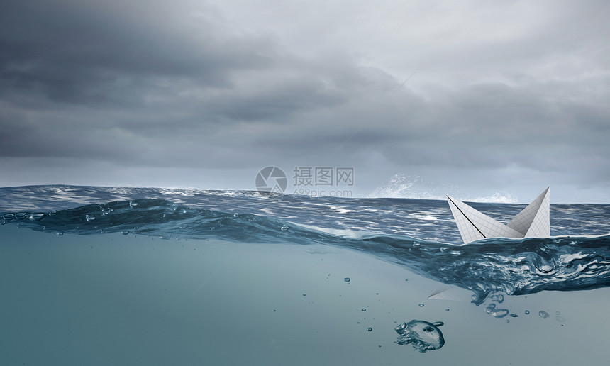 折纸船用纸制成的船沉蓝色的水上图片