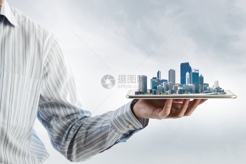 现代城市模式手持平板电脑,屏幕上城市景观图片