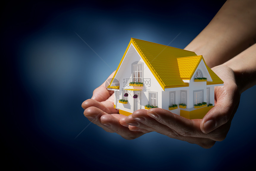 房地产人的手着梦想之家的模型图片