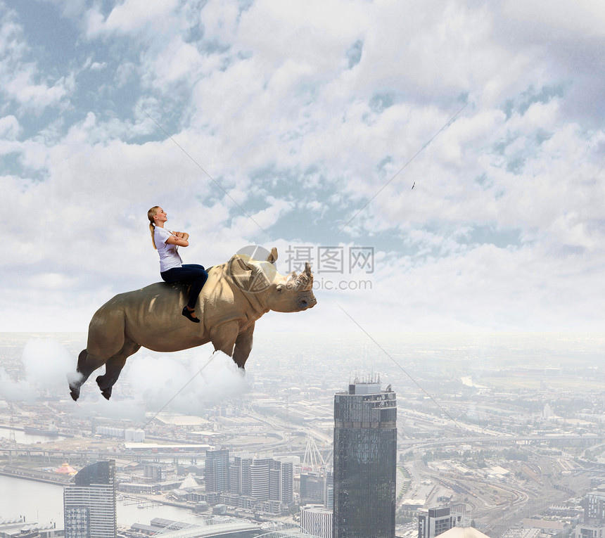 轻漂亮无畏的女人骑着巨大的飞行飞犀牛的女人图片