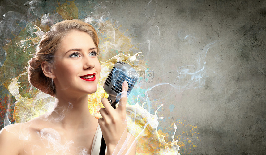女金发的形象歌手烟雾背景下着麦克风图片
