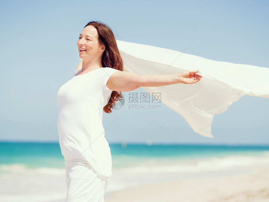 阳光明媚的天,海滩上穿着白色衣服的女人海滩上美好的天图片