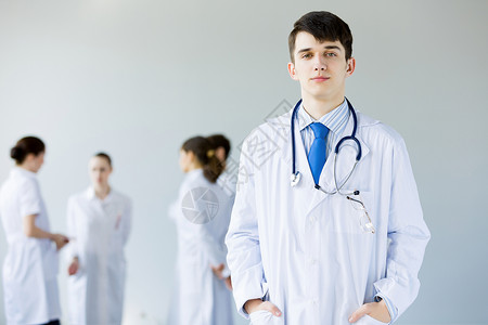 轻的医生穿着制服的轻医生背景的同事图片