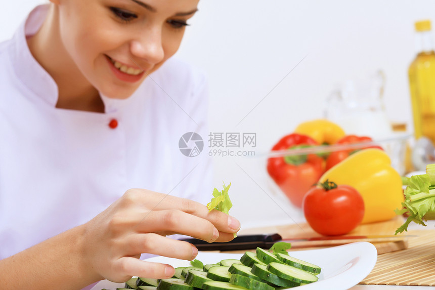 轻的厨师用红色围裙准备食物图片