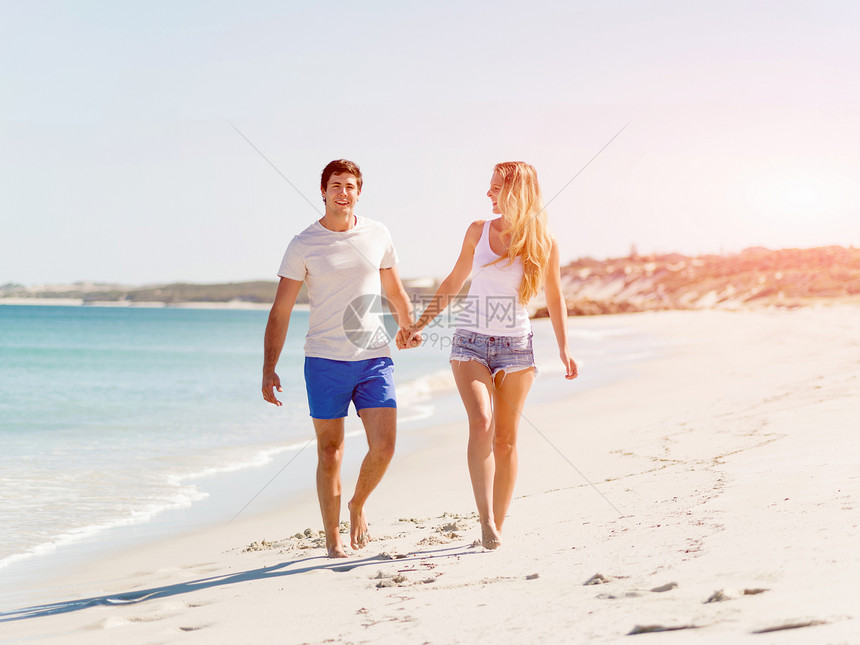 浪漫的轻夫妇海滩上浪漫的轻夫妇海滩上沿着海岸散步图片