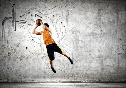 篮球运动员轻人跳跃中把球扔进篮子里图片